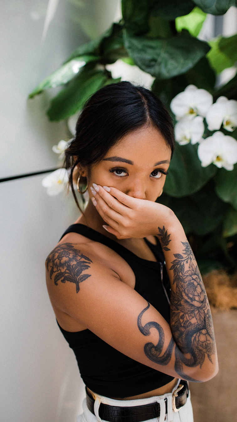 Photo of Tattooed Woman in Black Tank Top Posing